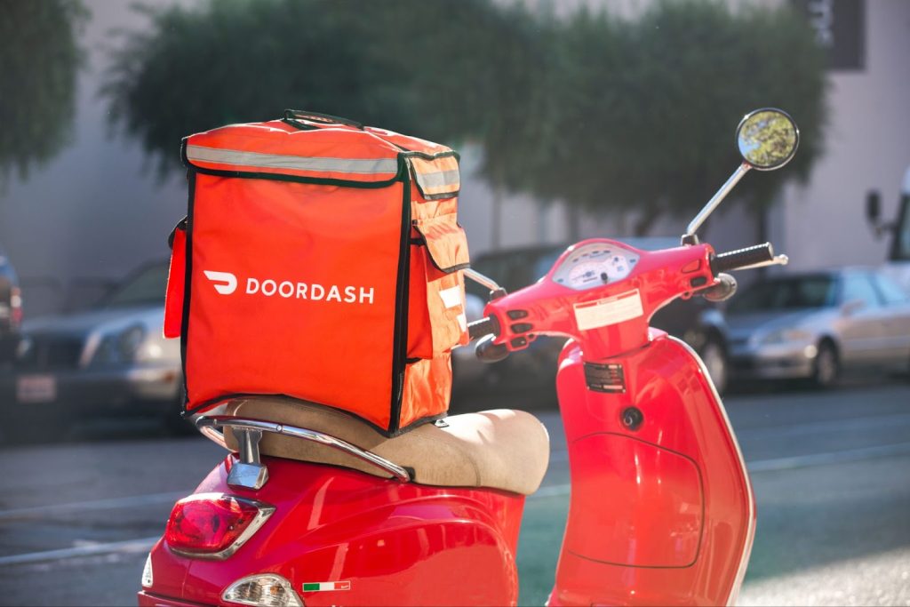 DoorDash logo on the outside of a bag ont he back of a motorbike